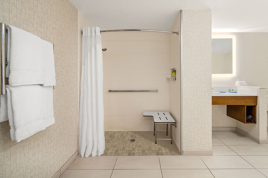 roll-in shower and grab bar in accessible guest bathroom