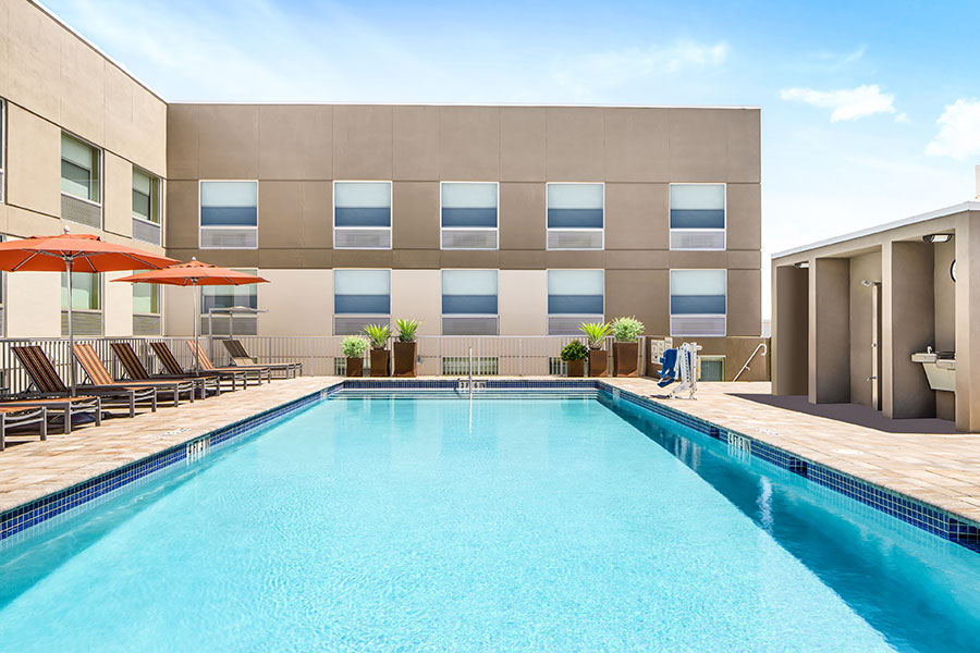 outdoor pool with lounge chairs and pool lift